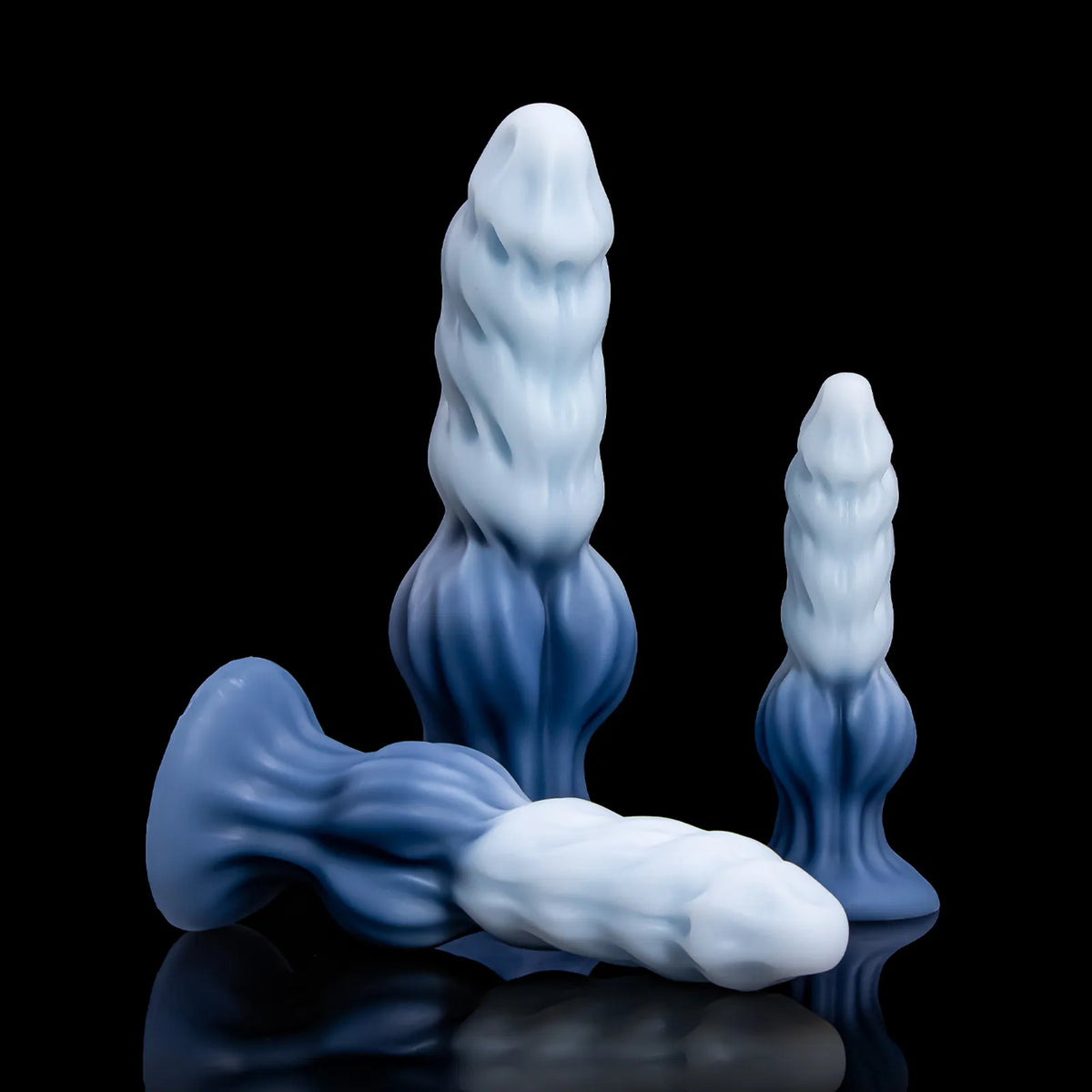 Two Nivaskel forms standing behind a third form lying across the foreground.