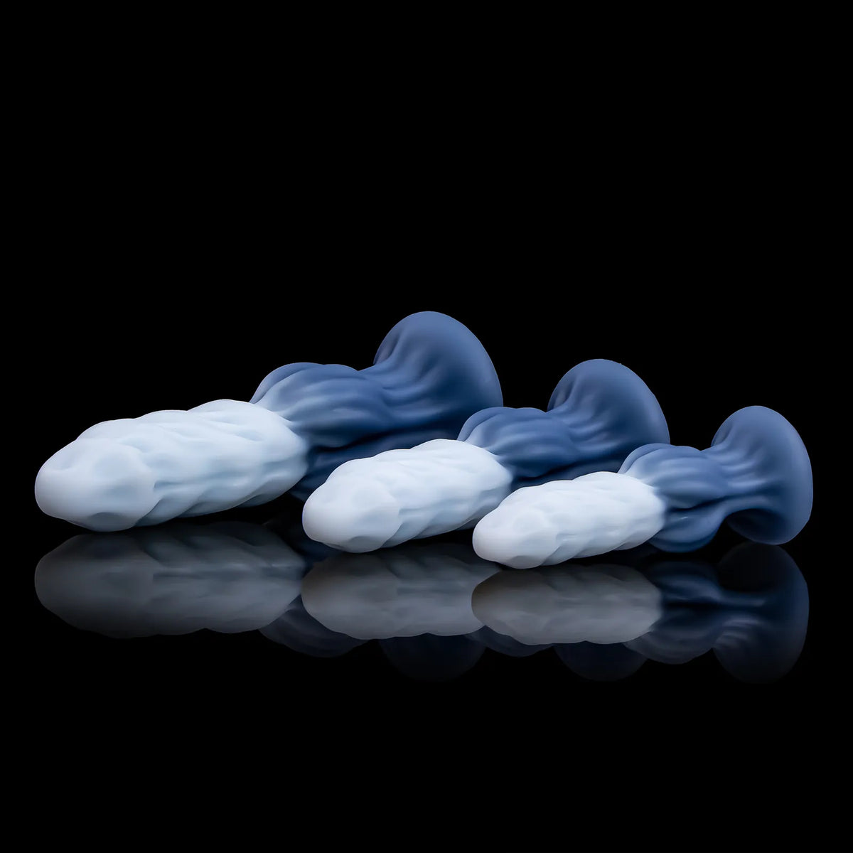 Three Nivaskel forms lying side by side, showing pale ridged shafts and blue flared bases.